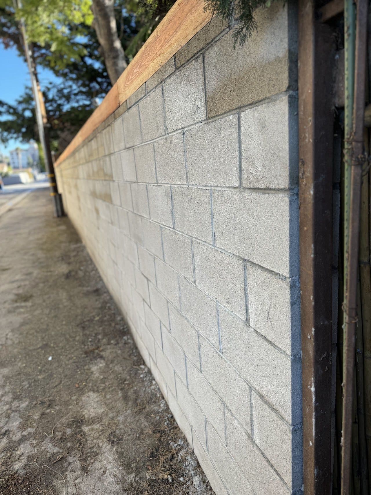 New concrete block wall with crisp mortar joints and a wood cap