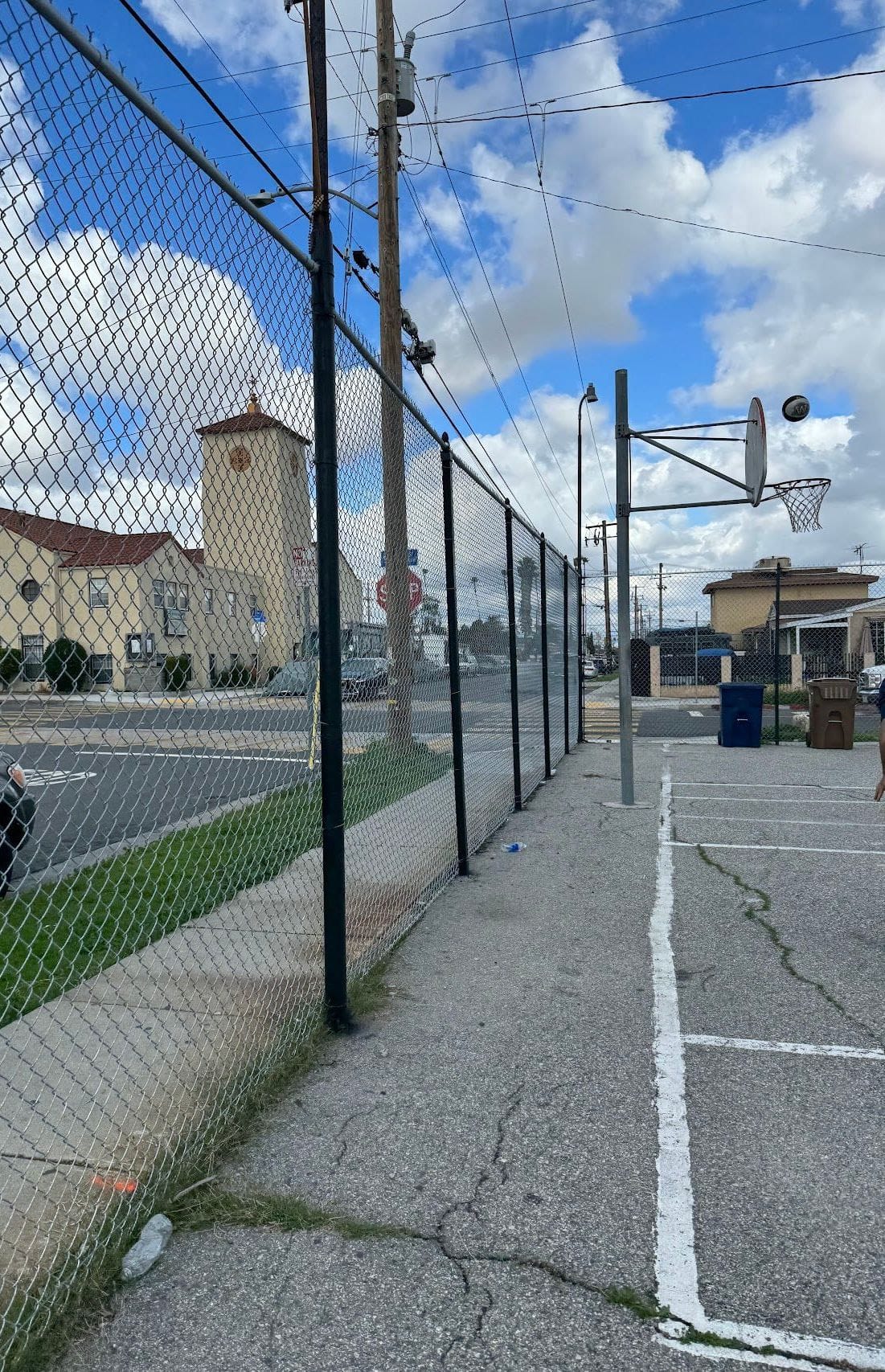 Long galvanized chain-link fence along a sports field