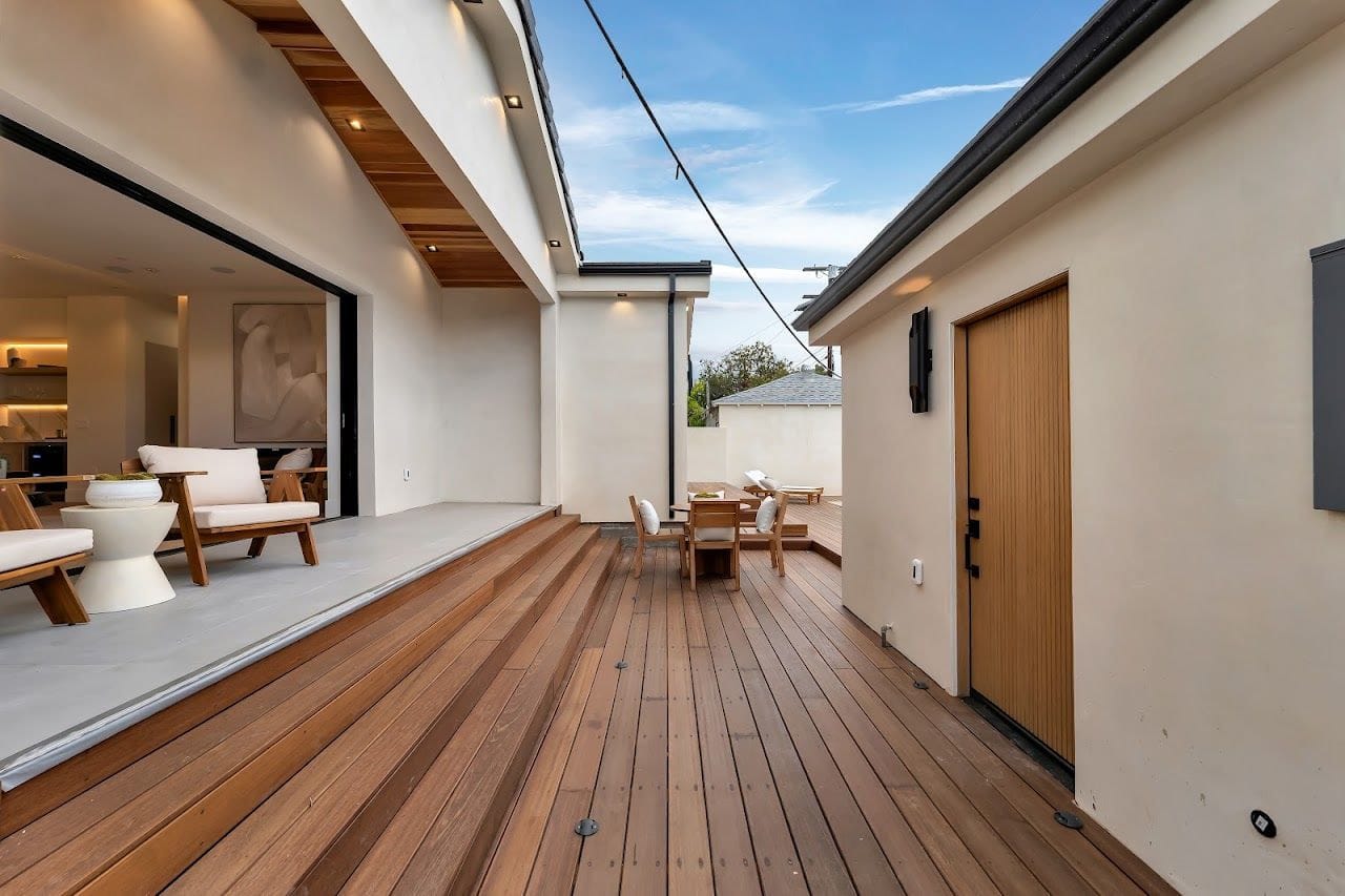 Hardwood deck boards and steps running along the back of a new home