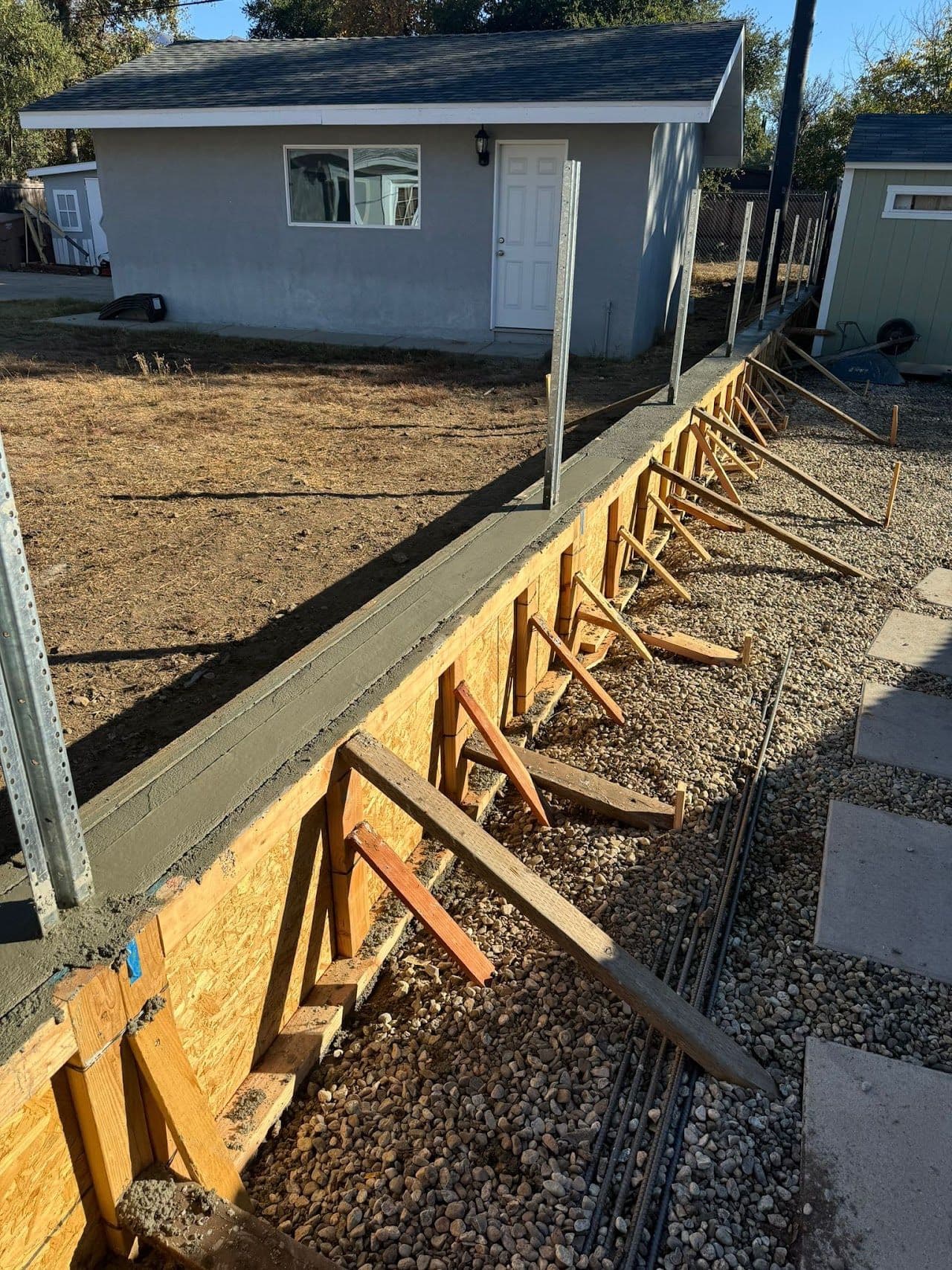Retaining wall under construction with posts set into the block