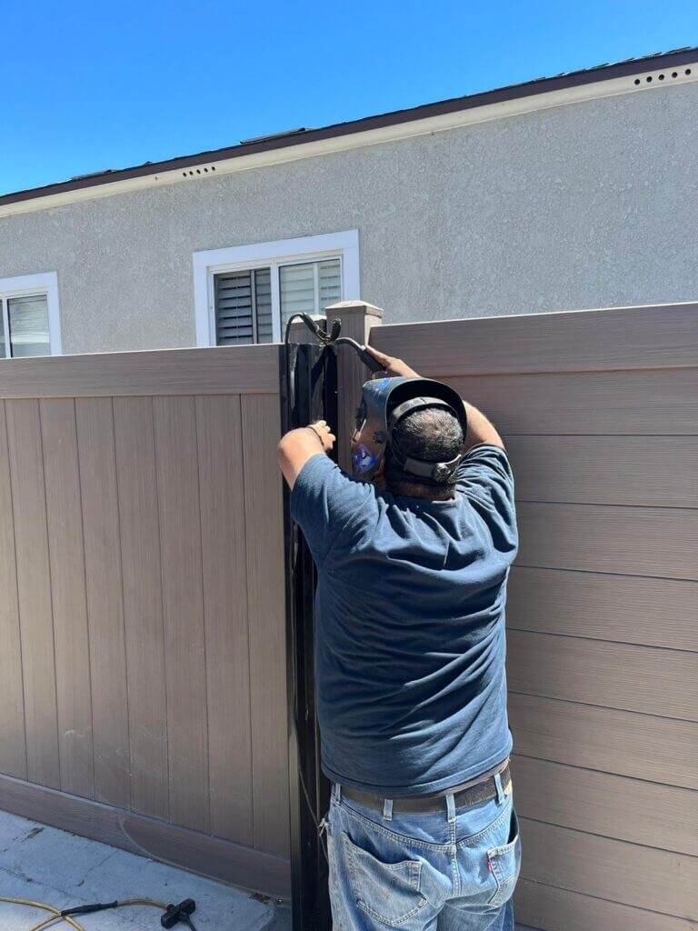 Working on metal fence installation